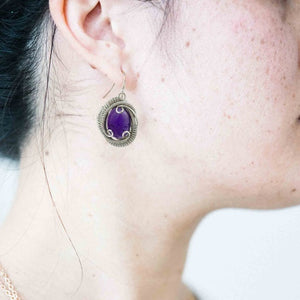 woman wearing amethyst wrapped earrings