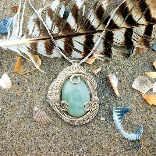 Larimar Heady wire wrapped pendant on a feather